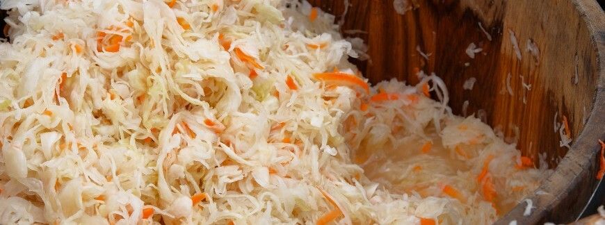 Kiszona kapusta z marchewką w drewnianej beczce podczas fermentacji. Fot. Ga_Na  - shutterstock.com