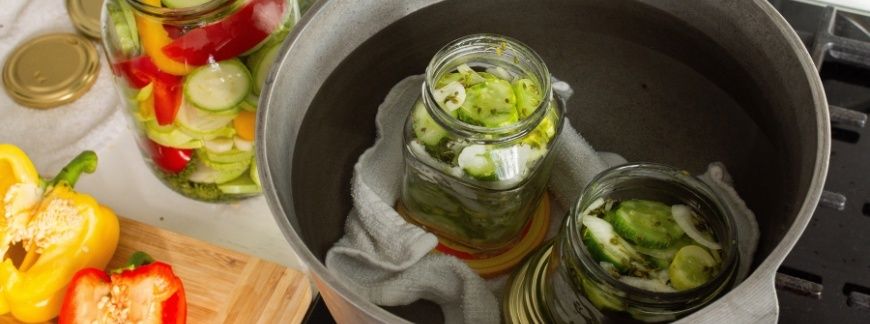Słoiki z warzywami przygotowywane do pasteryzacji w garnku z wodą. Fot. Pundapanda - shutterstock.com