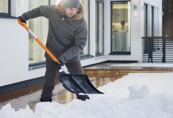 Odśnieżanie ogrodu zimą – usuwanie śniegu z alejek dużą łopatą Odśnieżanie ogrodu zimą – usuwanie śniegu z alejek dużą łopatą